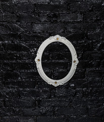 white elegant frame on a black brick wall