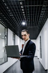 Young businessman in suit with laptop
