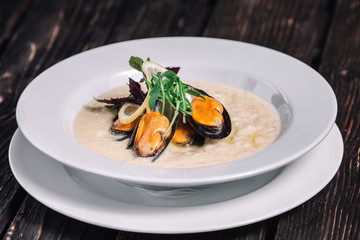 Risotto with mussels on dark wood background