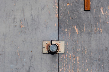 Old gray wooden wall with a circle metal lock