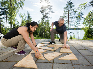 Friends Solving Wooden Planks Puzzle On Patio