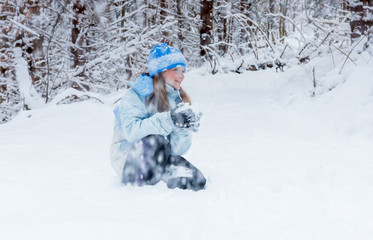 Fototapeta na wymiar girl enjoying day playing in winter forest