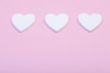 alla hjärtans dag bakgrund tre vita hjärtan på rad med utrymme för egen text mot rosa trä bakgrund - obrazy, fototapety, plakaty