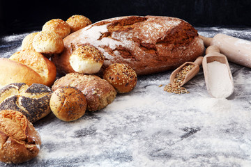 Different kinds of bread and bread rolls on black board. Kitchen or bakery poster design
