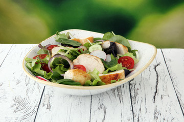 Chicken salad with leaf vegetables and cherry tomatoes.