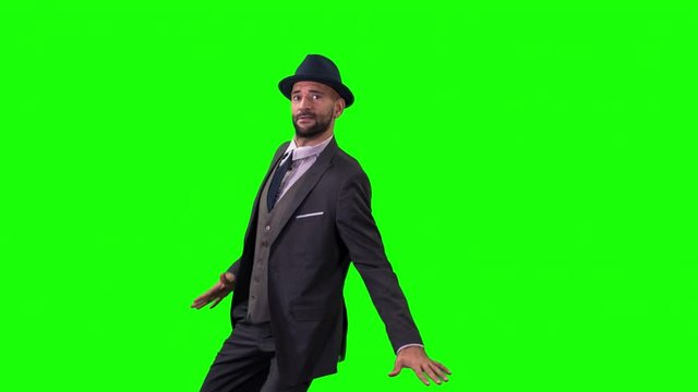 a skillful male dancer in a smart suit dancing in a contemporary style shot against greenscreen with alpha channel for easy keying