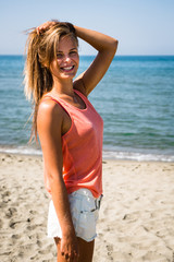 Beautiful blonde model with long hair walking on the beach