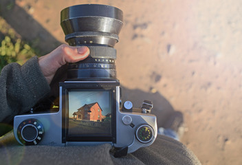 man photographer is making arhitecture photography with old film camera in spring,  home and building concept. top view. copyspace