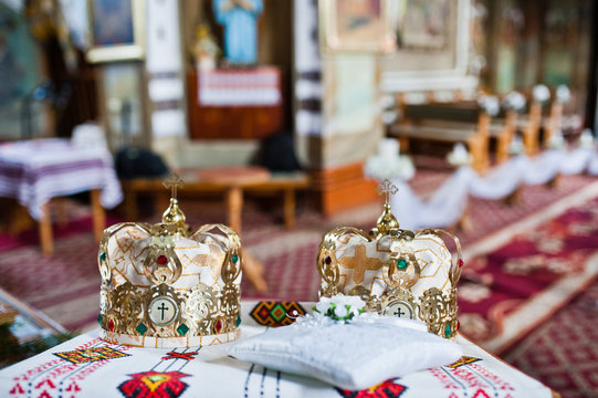 Close-up photo of wedding crowns in the church on the table.
