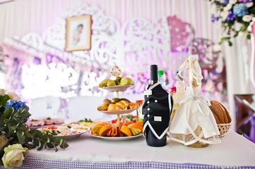 Close-up photo of decorated bottles on the table on wedding banquet.