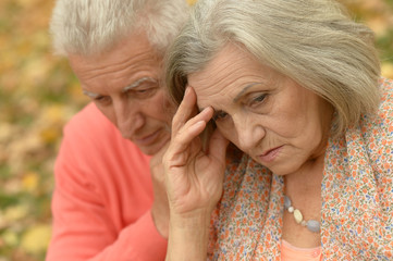 Sad senior couple in  park