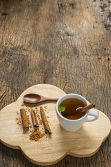 hot apple juice in cup with cinnamon and ground cinnamon on old wood. autumn food concept