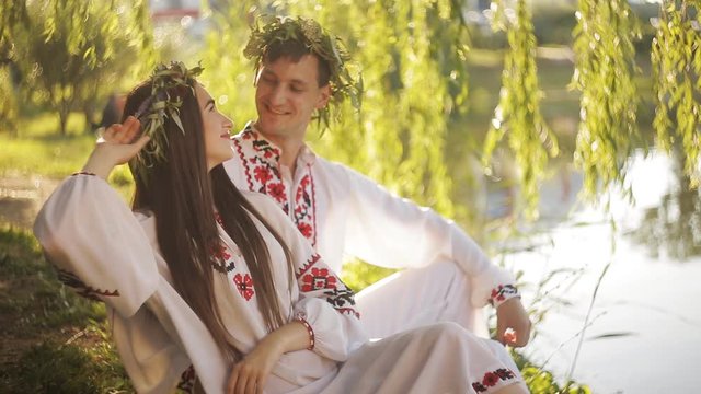 a romantic date on the riverbank. man and woman in the Slavic suit