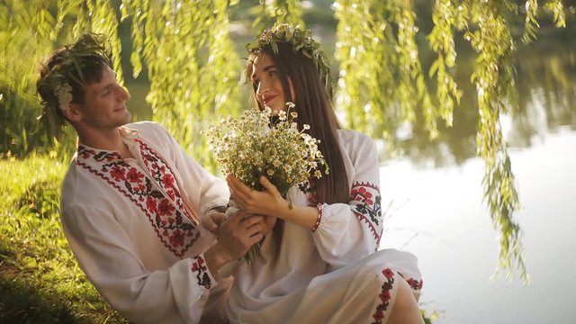 a romantic date on the riverbank. man and woman in the Slavic suit