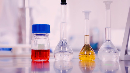 Laboratory flasks and beakers with liquids of different colors on lab table