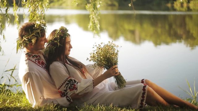 a romantic date on the riverbank. man and woman in the Slavic suit