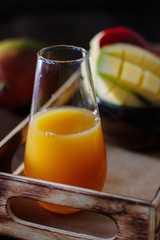 Glass with fresh mango juice in wooden box