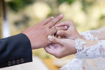 Obraz na płótnie Canvas Putting the wedding ring on finger in a holy matrimony
