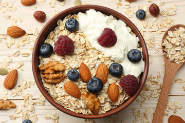 healthy breakfast. oatmeal, blueberries, raspberries and nuts on white wooden table. Top view