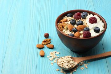 healthy breakfast. oatmeal, blueberries, raspberries and nuts on blue wooden table