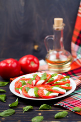 Delicious caprese salad with tomatoes and mozzarella cheese with basil leaves