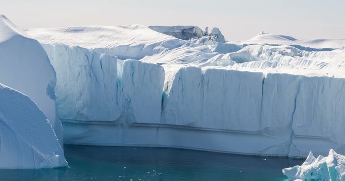 Iceberg aerial footage - giant icebergs in Disko Bay on greenland floating in Ilulissat icefjord from melting glacier Sermeq Kujalleq Glacier, aka Jakobhavns Glacier. Global warming and climate change