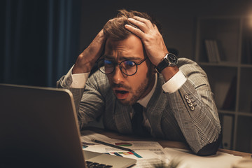 shocked businessman looking at laptop