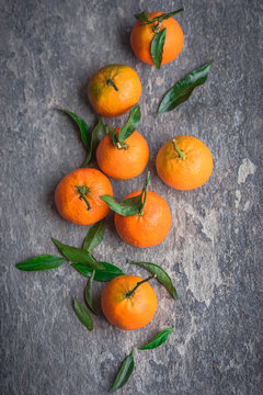 Ripe mandarins on a textured gray background. Top view.  Season of citrus fruits