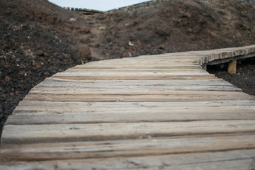 wooden path through lava stones