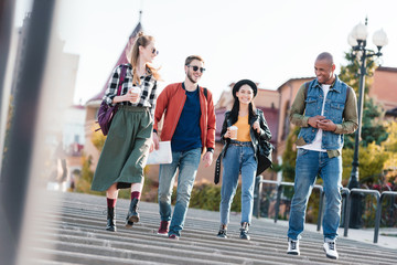 multicultural friends walking on street