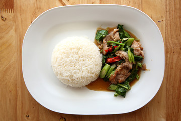 fried pork with Chinese Kale and rice on wood background , Thai food