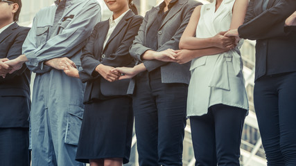Business people holding hands showing teamwork.