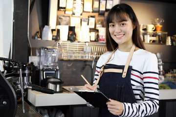 Fototapeta na wymiar Portrait of smiling asian barista listing food. Cafe restaurant service, food and drink industry concept.