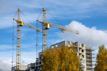 two tower crane at a construction site in the autumn