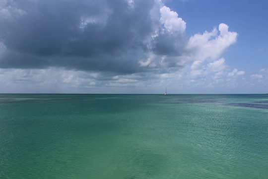 Una grossa nuvola scura porta l'ombra sul mare cristallino verde del Belize