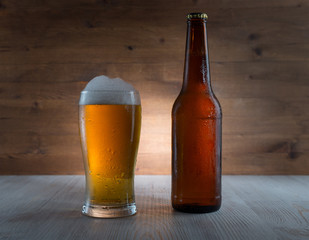 Glass of golden beer and bottle