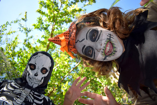 Little witch and skeleton in Halloween party 