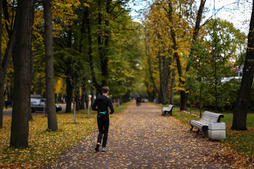 мужчина бегает в осеннем парке 