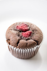 Chocolate cup cake muffin with raspberries isolated on the white plate
