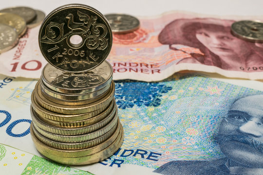 stack of krone coins on banknotes, norwegian money close up