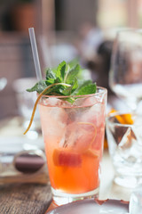 Cold ginger and grapefruit mojito cocktail with mint in icy highball glass for hot summer day, fresh aperitif on restaurant table