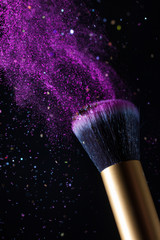Cosmetics makeup brush and powder dust explosion background. Sequins fly