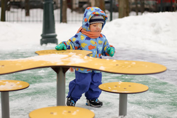 Kid play on the Playground in winter