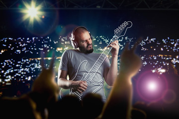 Mann hört Musik mit Kopfhörern und spielt E - Gitarre
