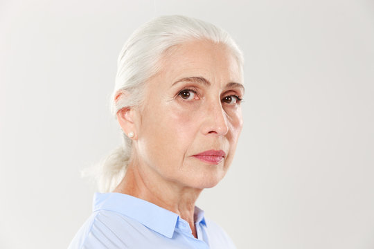 Side view photo of serious mature woman, looking at camera