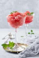 Watermelon granite with mint, summer refreshing drink in glass on a gray concrete background. Selective focus.