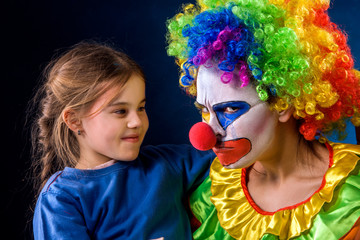 Single parent family. Tired mom after work as clown on birthday on dark background. Adult child relationship. Social problem mad parent. Human hates children.