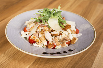 Salad with chicken, mozzarella and cherry tomatoes. Caesar salad served at a restaurant.