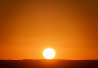 Beautiful sunset with orange sky and complete sun