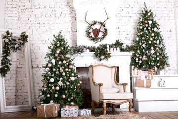 Christmas tree and a chair stands near the fireplace  and other holiday decorations in white loft